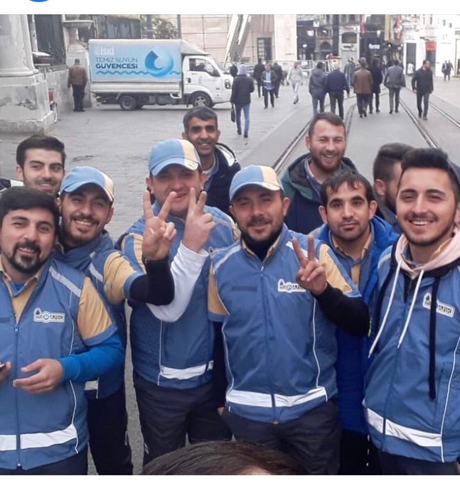 zafer işareti yaparak poz veren ispark çalışanları