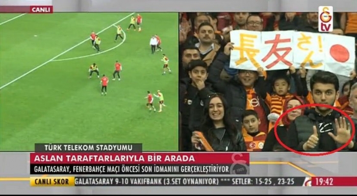 gs taraftarının arasında 6 0 işareti yapan genç